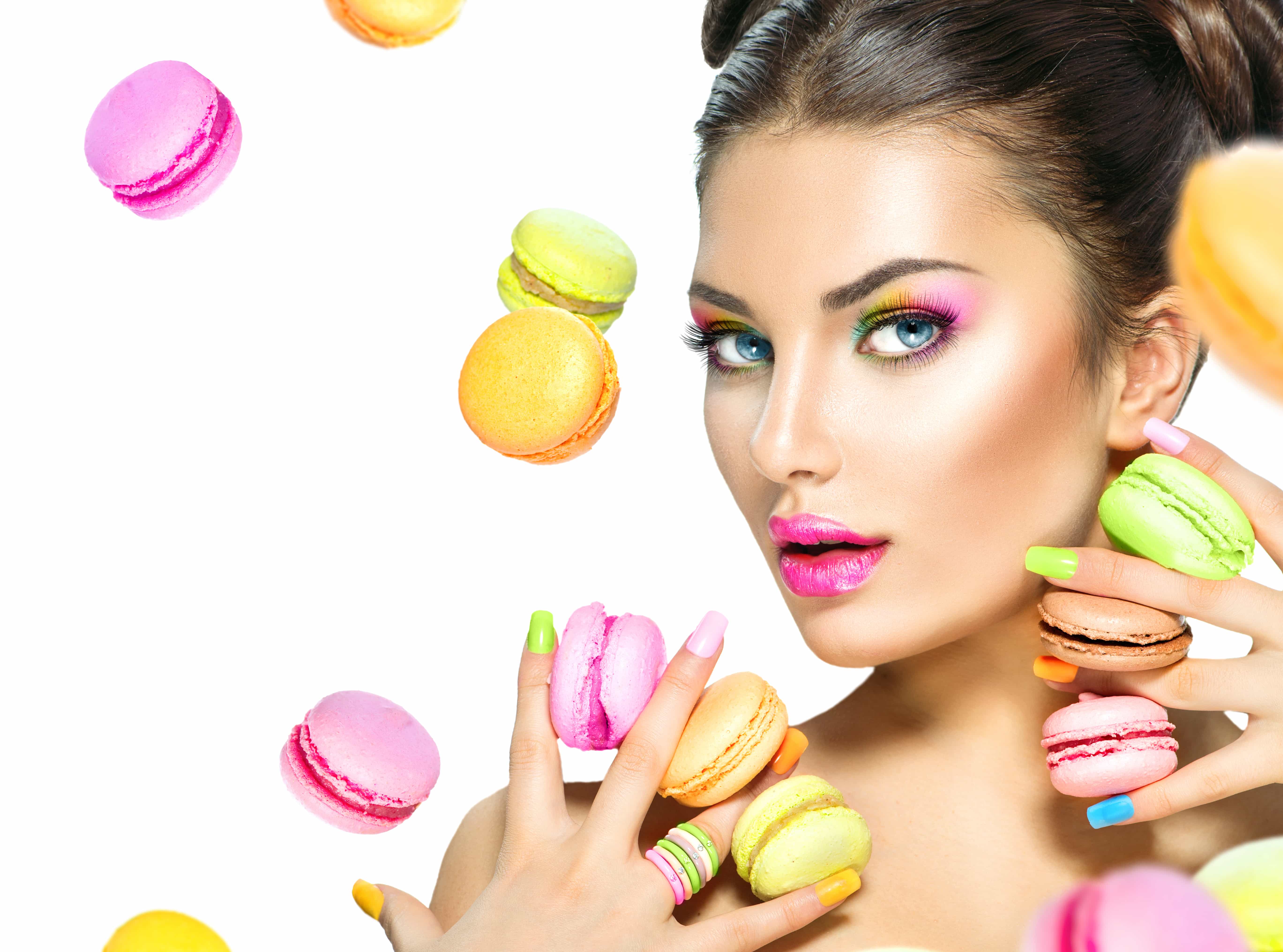 Beauty fashion model girl taking colorful macaroons